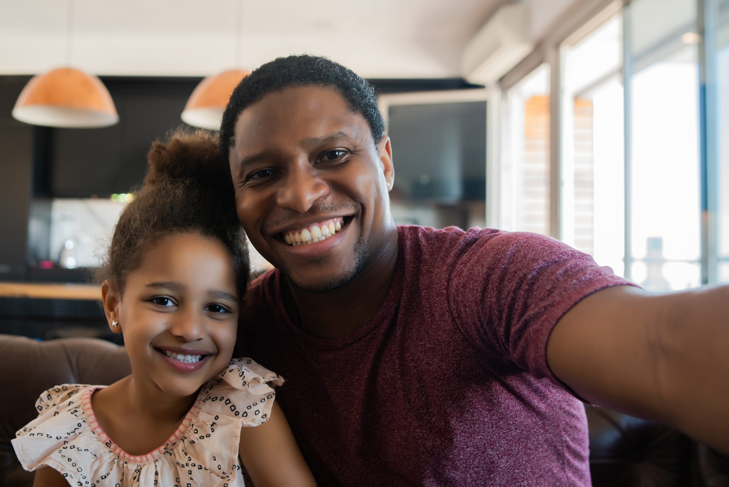 Daughter and father taking a selfie at home.